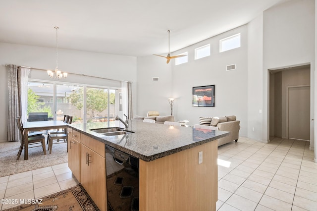 kitchen with light brown cabinets, a healthy amount of sunlight, black dishwasher, a sink, and light tile patterned floors