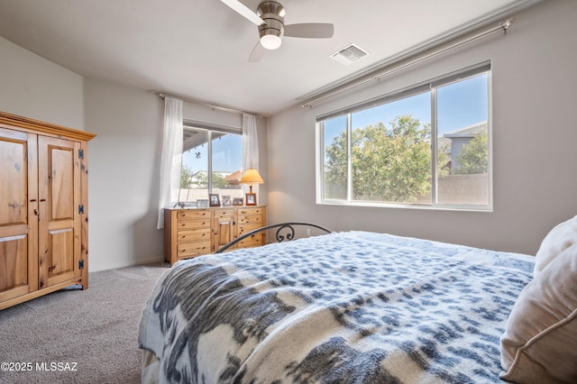bedroom featuring a ceiling fan, visible vents, and light carpet