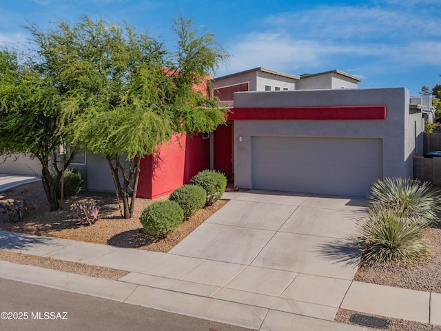 view of front of property featuring stucco siding, driveway, and a garage