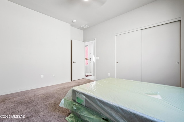 bedroom featuring carpet floors, visible vents, and a closet