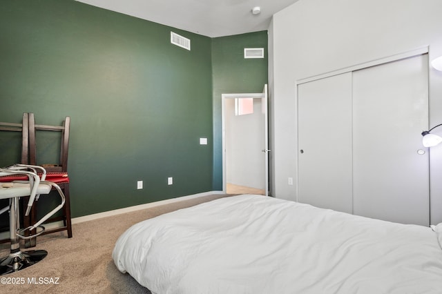 carpeted bedroom featuring baseboards, visible vents, and a closet