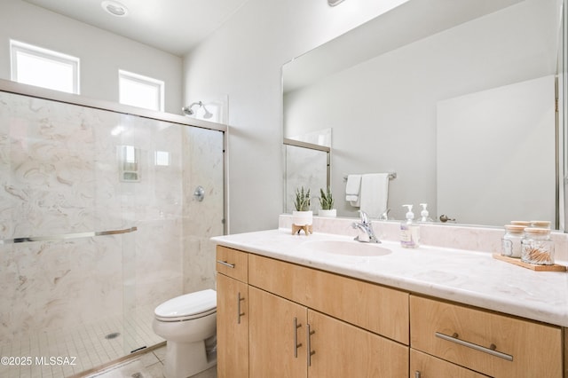 full bathroom featuring vanity, a marble finish shower, tile patterned floors, and toilet
