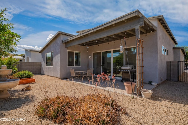 back of house featuring a patio area, stucco siding, and fence