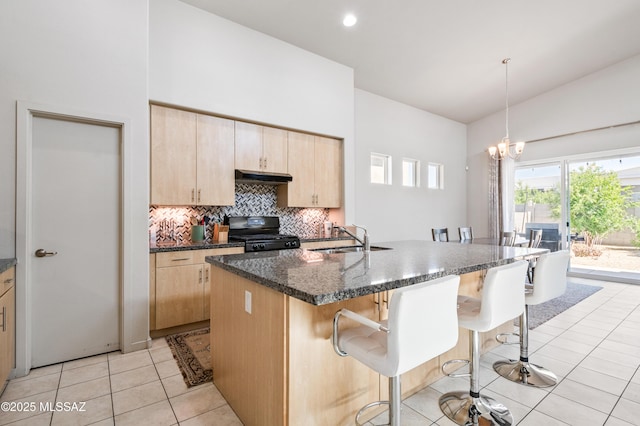 kitchen featuring light brown cabinets, black range with gas stovetop, under cabinet range hood, a sink, and light tile patterned floors