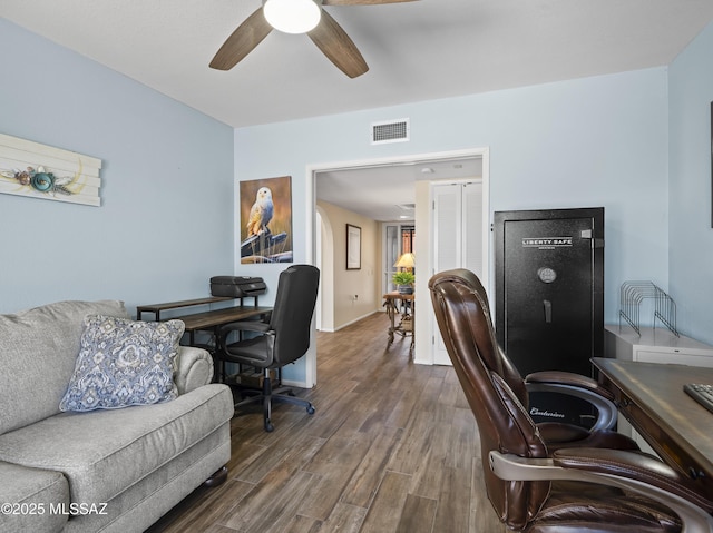 office space featuring baseboards, a ceiling fan, wood finished floors, and visible vents