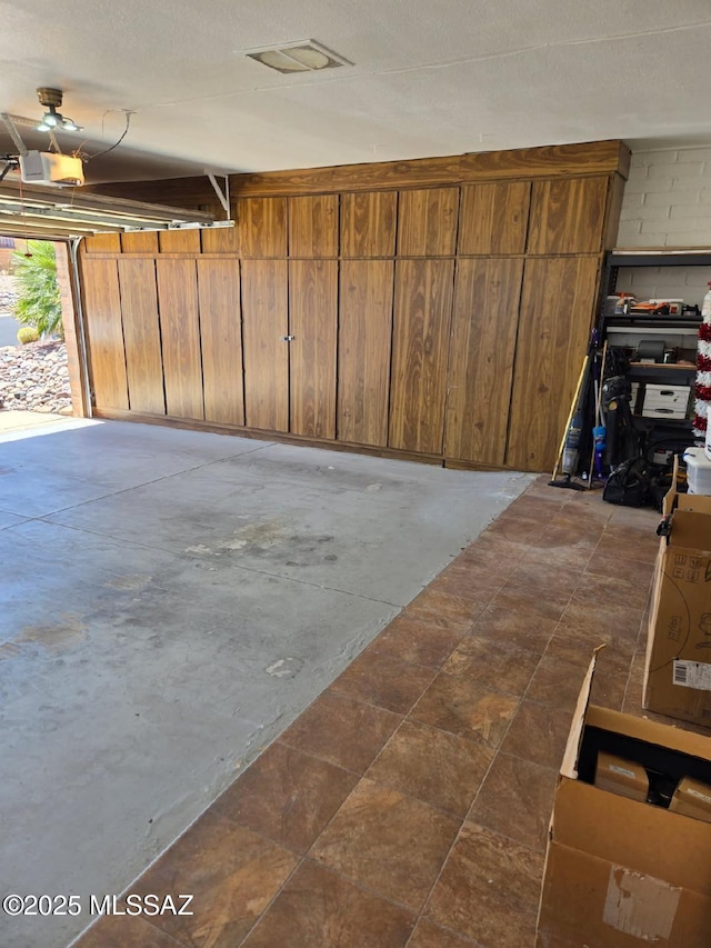 garage featuring wood walls and a garage door opener