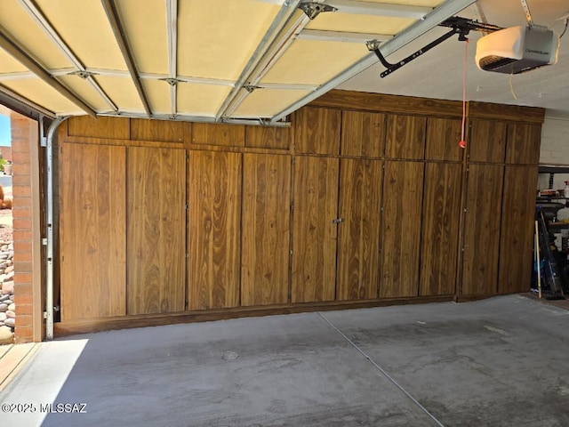 garage featuring wooden walls and a garage door opener