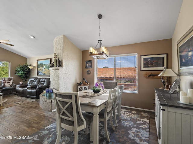 dining room featuring baseboards, dark wood finished floors, ceiling fan with notable chandelier, and vaulted ceiling