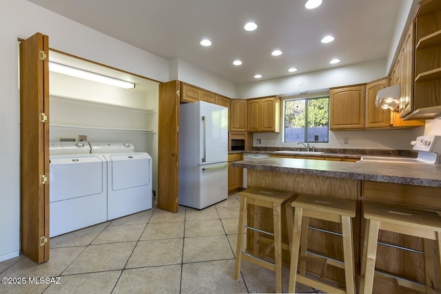 2102 E Florence Dr, Tucson, AZ 85719 - kitchen featuring white refrigerator, independent washer and dryer, stove, a peninsula, and dark countertops