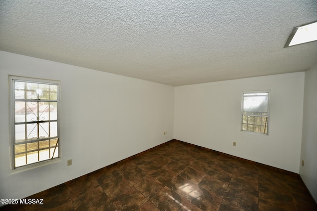 empty room featuring a textured ceiling and plenty of natural light