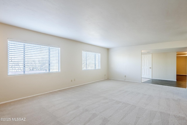 carpeted spare room with baseboards