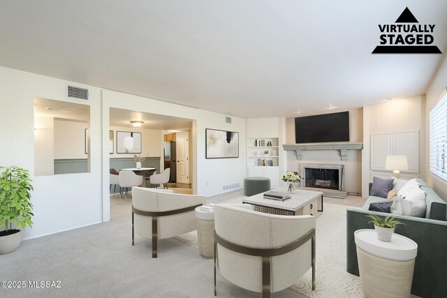 living room with baseboards, visible vents, light carpet, and a fireplace