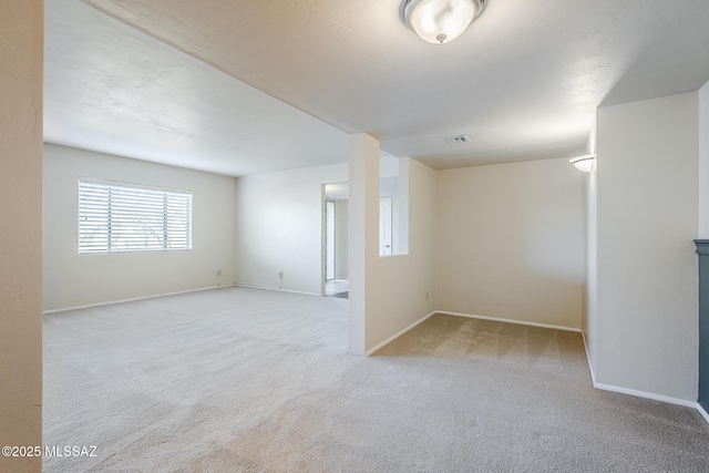 carpeted empty room with baseboards and visible vents
