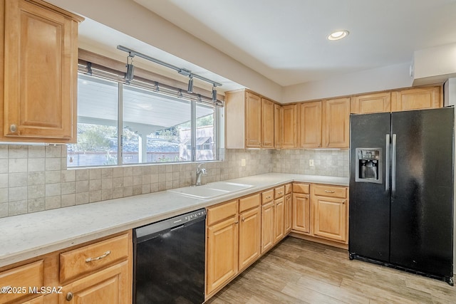 kitchen featuring a sink, light brown cabinetry, and black appliances