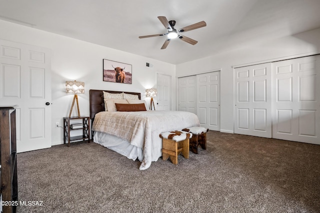 bedroom with multiple closets, a ceiling fan, dark colored carpet, and visible vents
