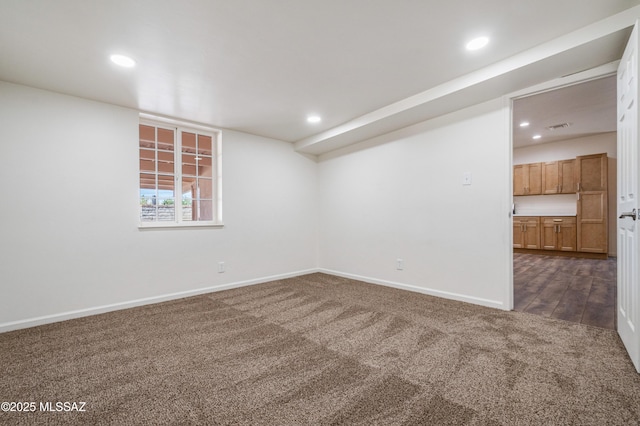 empty room featuring dark colored carpet, recessed lighting, and baseboards