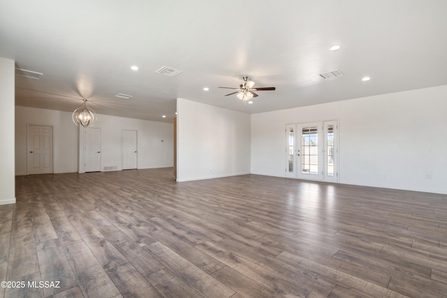 unfurnished living room featuring a ceiling fan, wood finished floors, recessed lighting, a chandelier, and baseboards