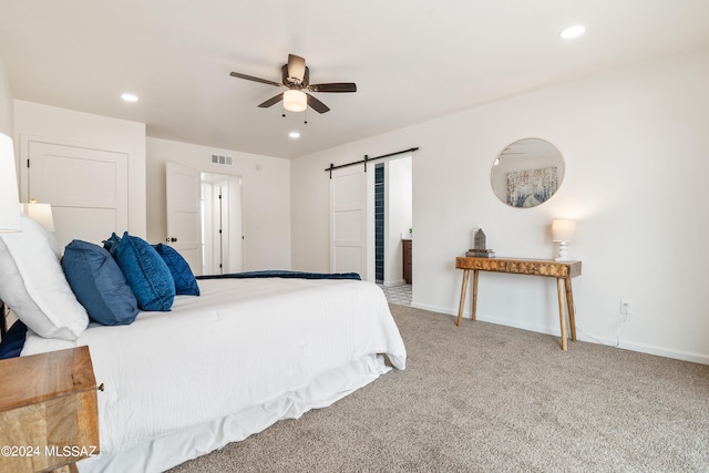 carpeted bedroom with baseboards, recessed lighting, a barn door, and visible vents
