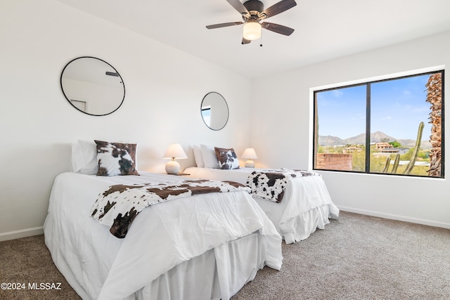 bedroom with carpet floors, baseboards, a mountain view, and ceiling fan