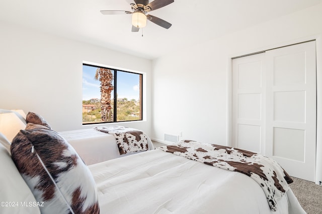 bedroom with carpet floors, a ceiling fan, baseboards, visible vents, and a closet