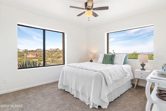 bedroom featuring baseboards, ceiling fan, and light carpet