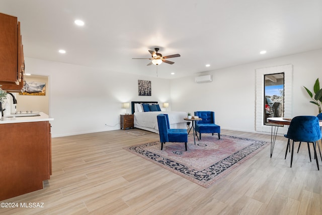 bedroom featuring baseboards, a sink, light wood finished floors, and recessed lighting