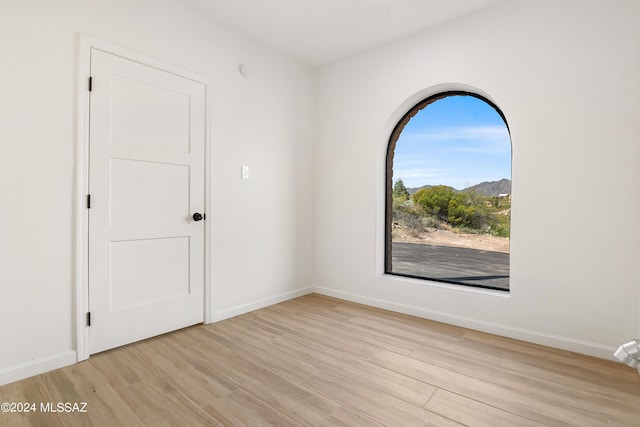 empty room featuring baseboards and wood finished floors