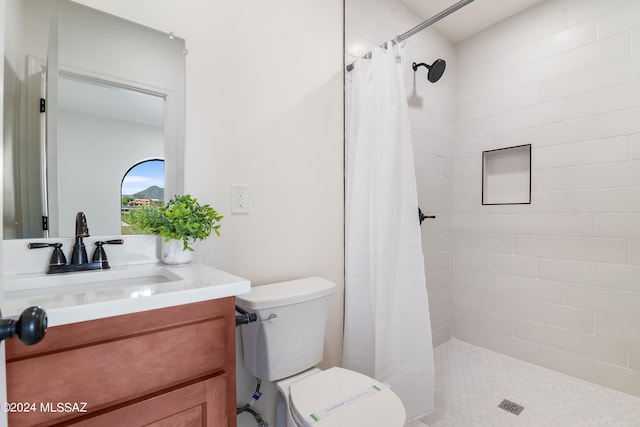 full bath with vanity, toilet, and tiled shower