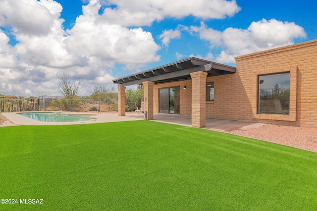 back of house featuring a patio, a lawn, fence, and a fenced in pool