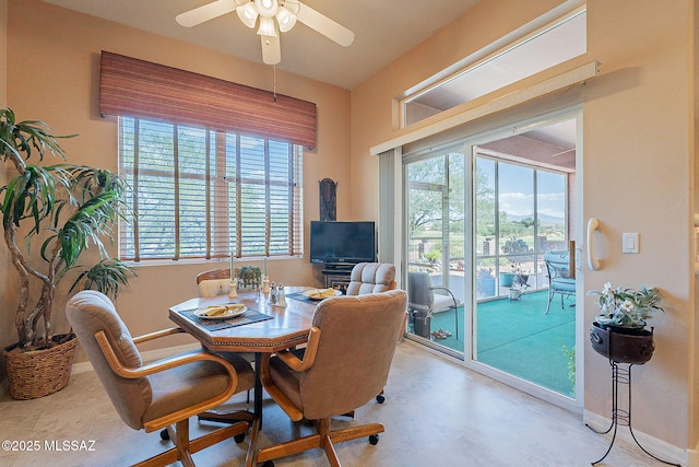 dining space featuring ceiling fan and baseboards