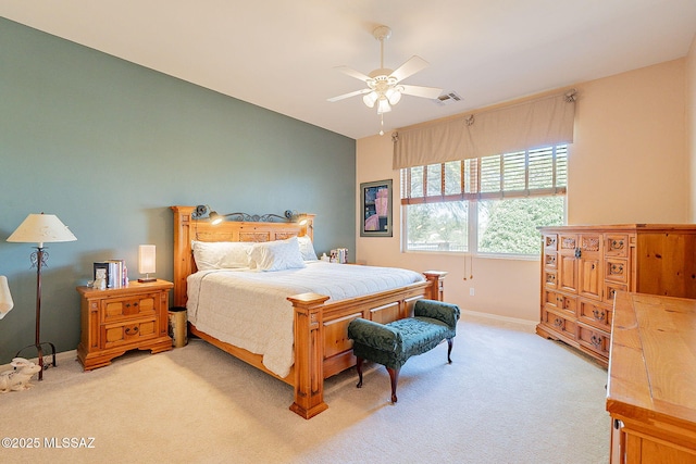 bedroom with visible vents, a ceiling fan, baseboards, and light colored carpet