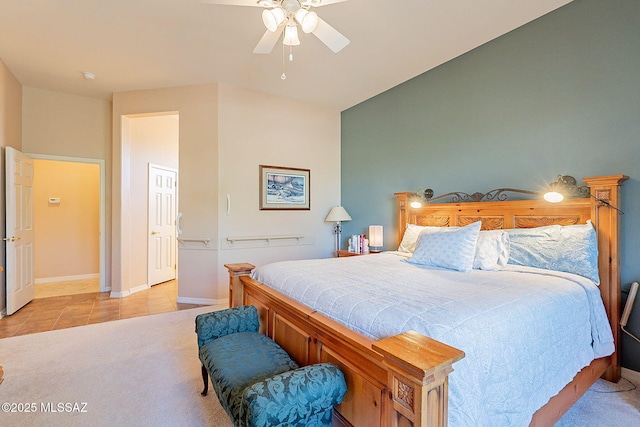 bedroom featuring baseboards, ceiling fan, light tile patterned floors, and light carpet
