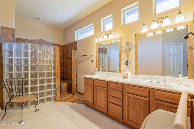 bathroom with double vanity, a walk in shower, a high ceiling, and a sink