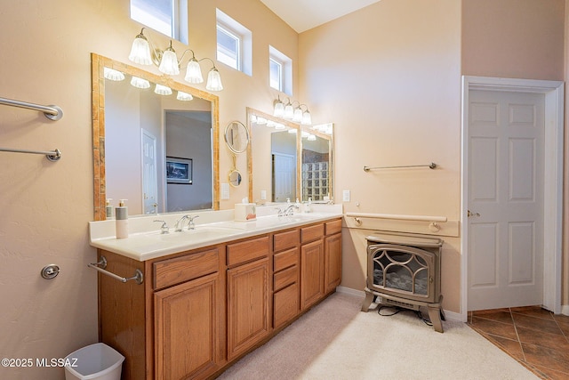 bathroom with double vanity, a high ceiling, and a sink