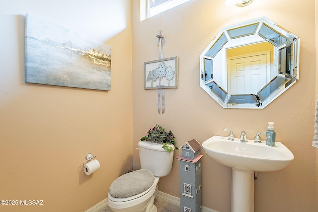 bathroom with baseboards and toilet
