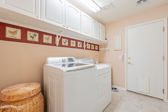washroom featuring cabinet space, baseboards, visible vents, and washing machine and dryer