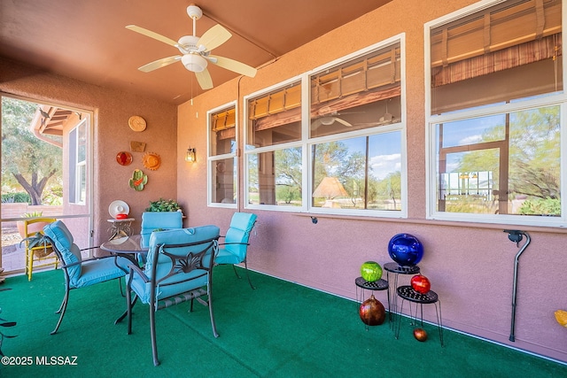 sunroom featuring a healthy amount of sunlight, ceiling fan, and outdoor dining space