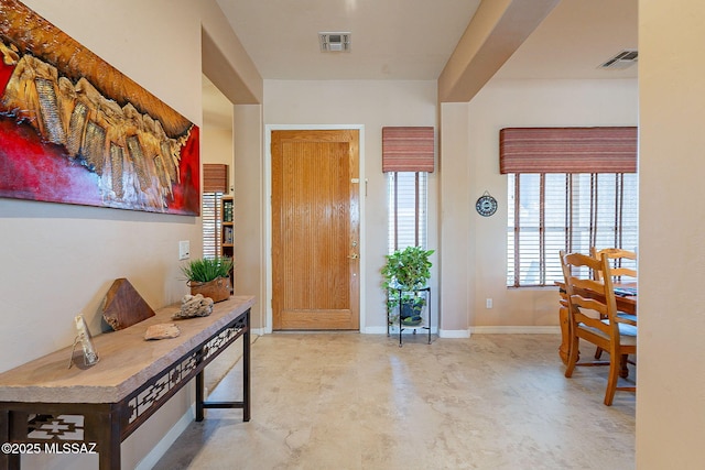 foyer with visible vents, finished concrete flooring, and baseboards