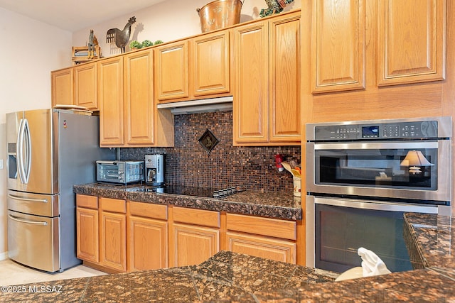 kitchen featuring tile counters, decorative backsplash, appliances with stainless steel finishes, and under cabinet range hood