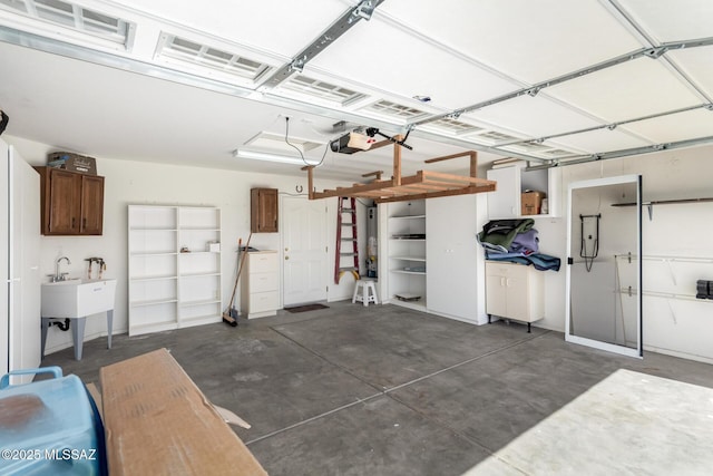 garage with a garage door opener and a sink