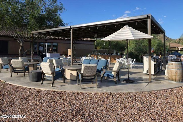 view of patio with an outdoor living space with a fire pit