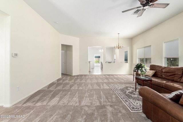 living room featuring carpet and ceiling fan with notable chandelier