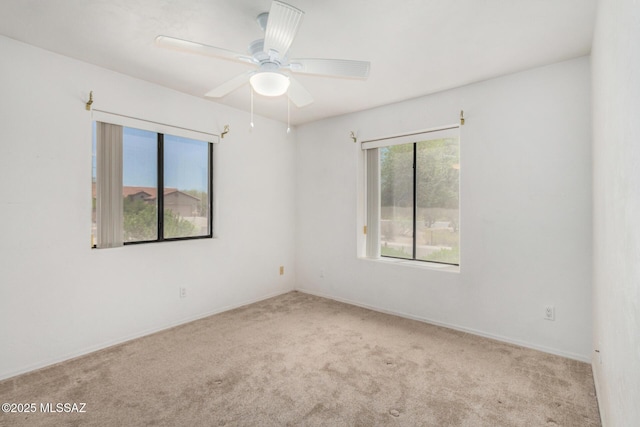 spare room with baseboards, ceiling fan, and carpet floors