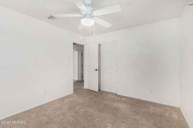 unfurnished bedroom with baseboards, carpet flooring, visible vents, and a ceiling fan
