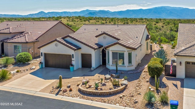 60333 E Ankole Dr, Oracle, AZ 85623 - mediterranean / spanish house featuring an attached garage, stucco siding, a mountain view, a tile roof, and concrete driveway