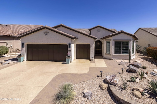 60333 E Ankole Dr, Oracle, AZ 85623 - mediterranean / spanish-style house featuring an attached garage, stucco siding, and concrete driveway