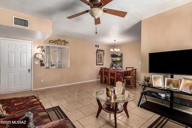 living area featuring baseboards, visible vents, light tile patterned flooring, and ceiling fan with notable chandelier