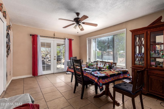 dining space featuring light tile patterned floors, french doors, a ceiling fan, and a textured ceiling