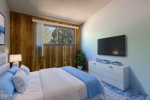 carpeted bedroom featuring wood walls