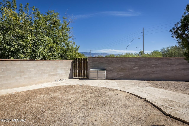 view of patio featuring fence and a gate
